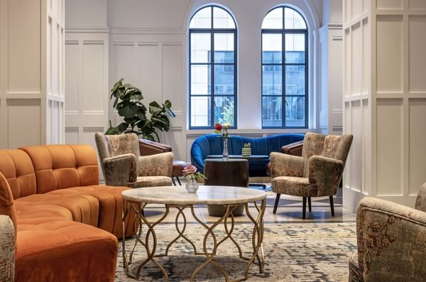 Elegant lounge area with orange couches, blue sofa, and stylish chairs at Warwick Allerton Chicago
