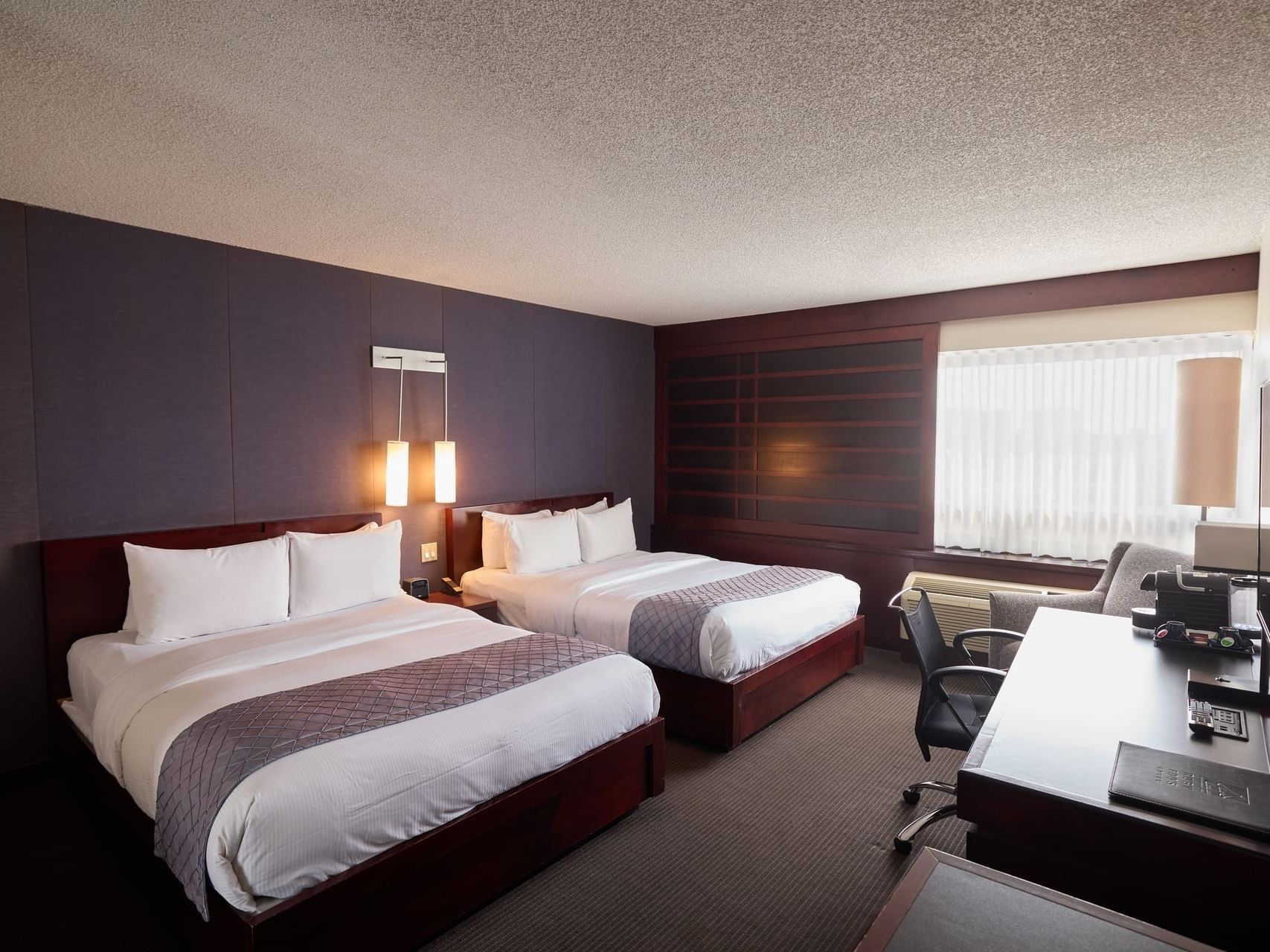 Beds & working area in Deluxe 2-Queen Room at Ruby Foo's Hotel