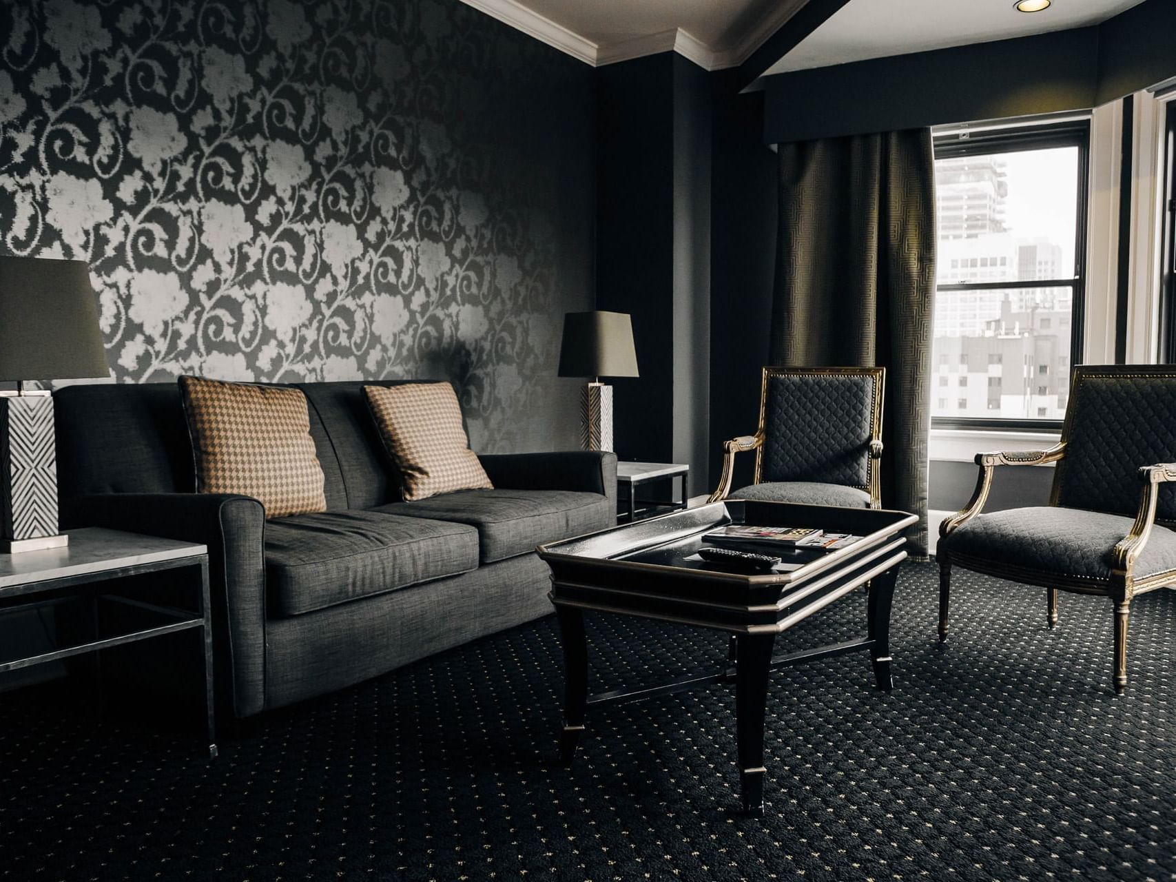 Chic lounge area featuring a dark floral patterned wall and plush seating in Designer Suites at Hotel Sorrento