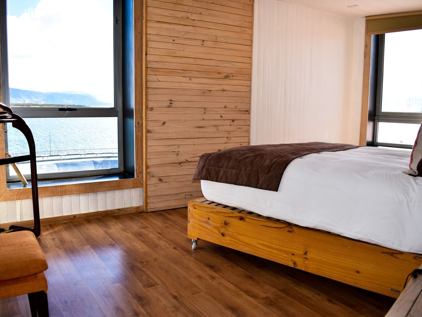 Quarto Deluxe Superior com painéis de madeira e grande janela no NOI Indigo Patagonia, hotel em Puerto Natales