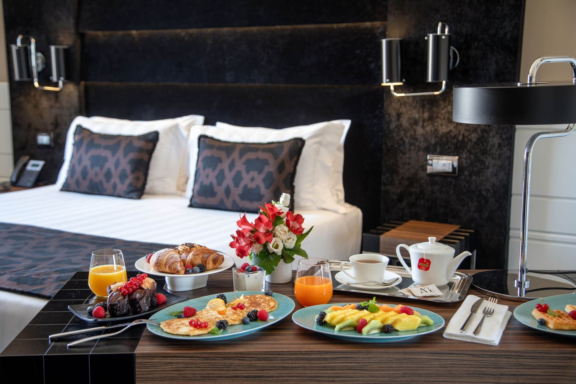 Lavish breakfast spread featuring pancakes, pastries, fruit, and drinks in Superior Room at The Glam Hotel
