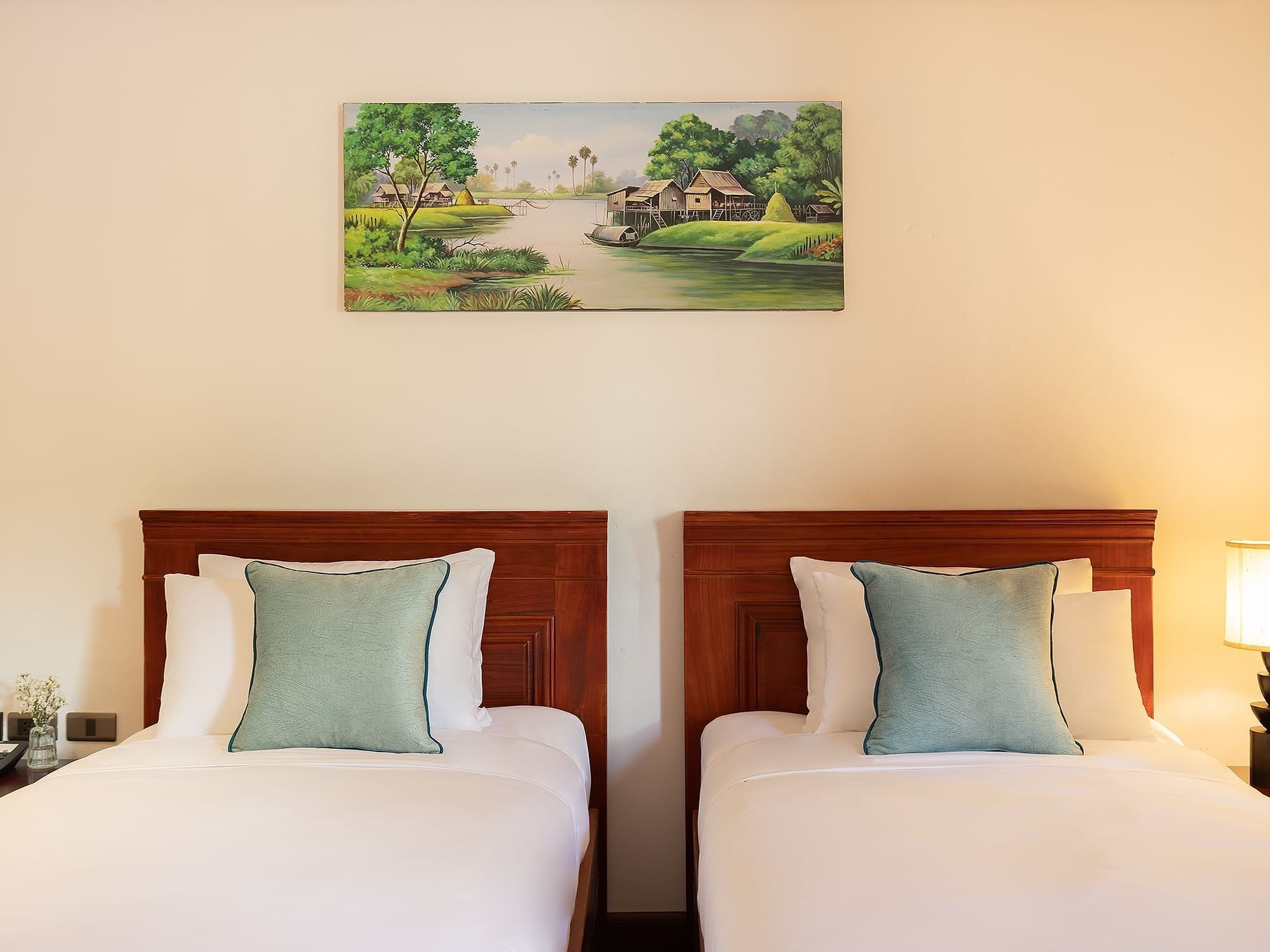 Two beds with nightstand and painting on the wall in Deluxe with Bathtub at U Luang Prabang