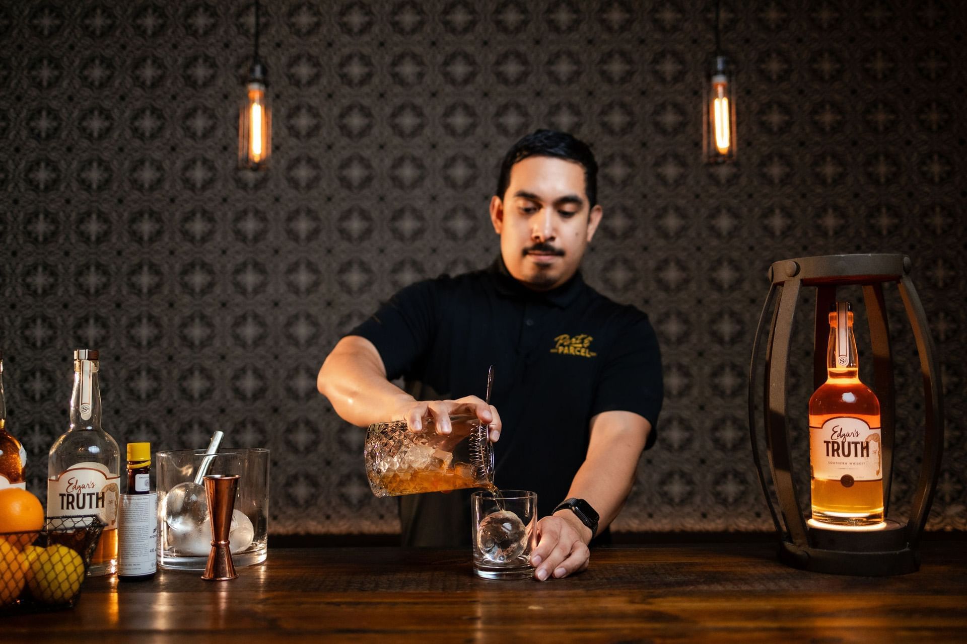 A bartender prepares a drink at a bar.