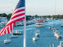 USA flag with ferries parked by the dock near Falmouth Tides