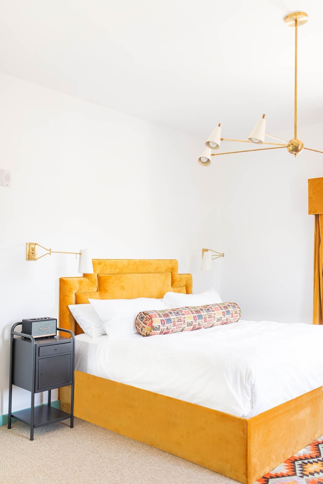 bed with orange bedframe in white room