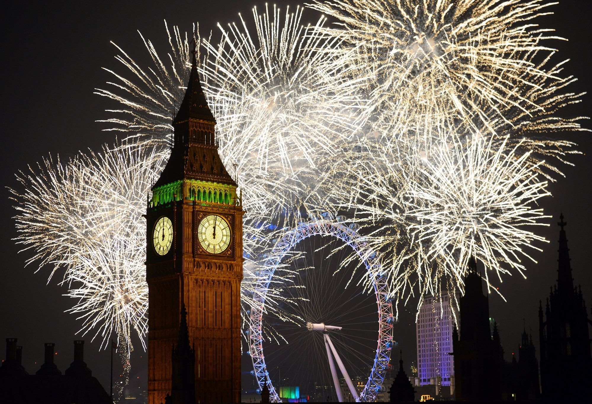 Iconic Big Ben and the London Eye illuminated by spectacular New Year’s Eve fireworks near The Londoner