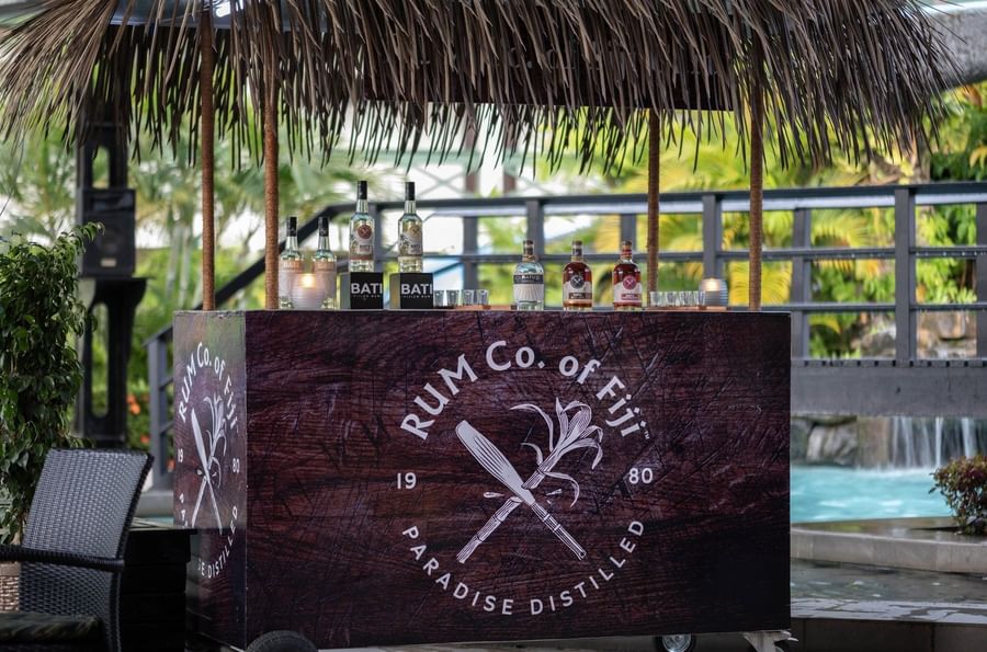 Outdoor cart with Rum Co. of Fiji bottles and logo at Tokatoka Resort - Fiji International Airport.