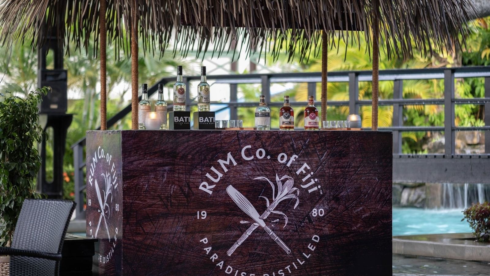 Poolside Bar with bottles under a thatched roof by a pool area at TokaToka Resort Nadi Fiji