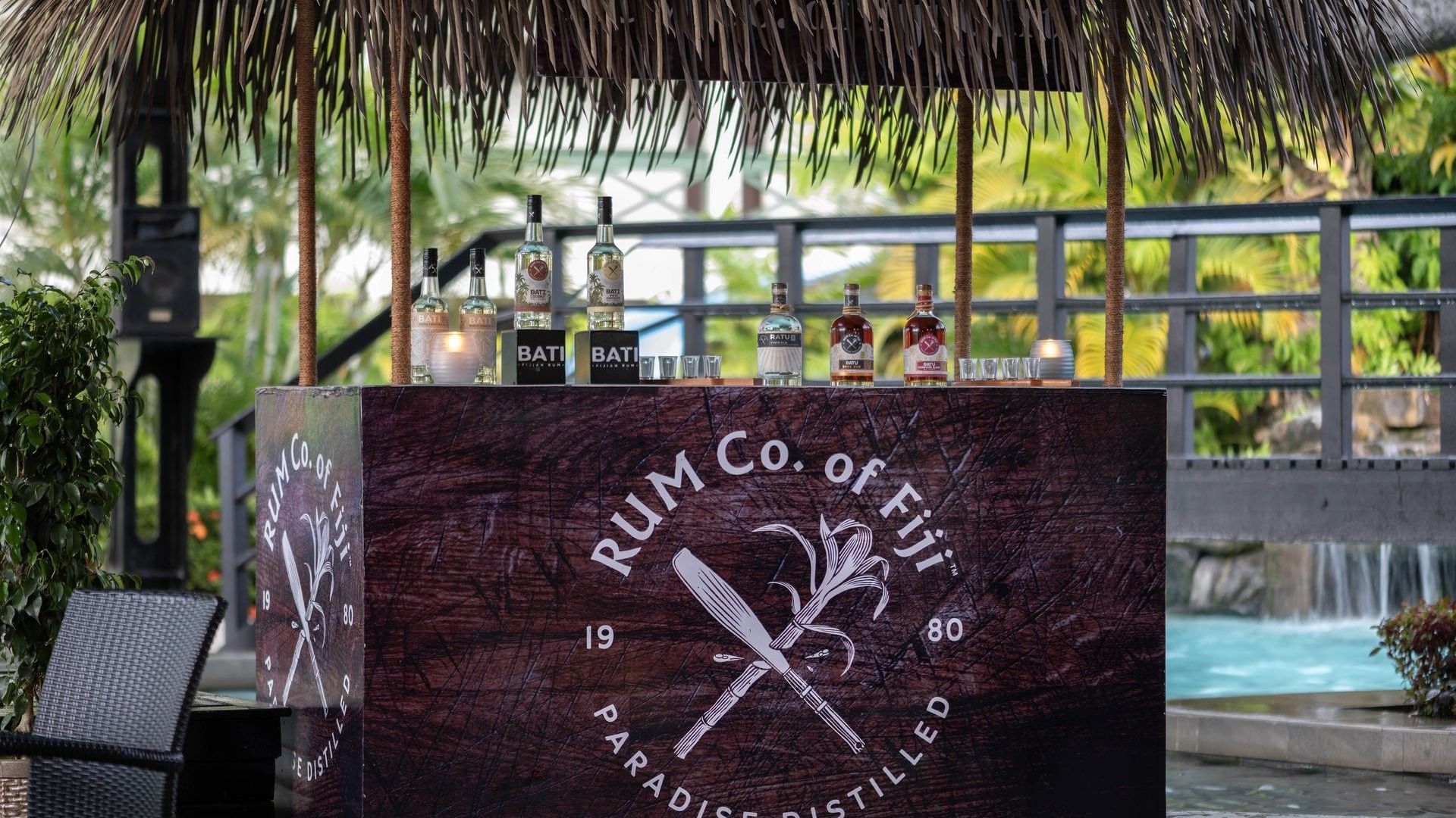 Poolside Bar with bottles under a thatched roof by a pool area at TokaToka Resort Nadi Fiji