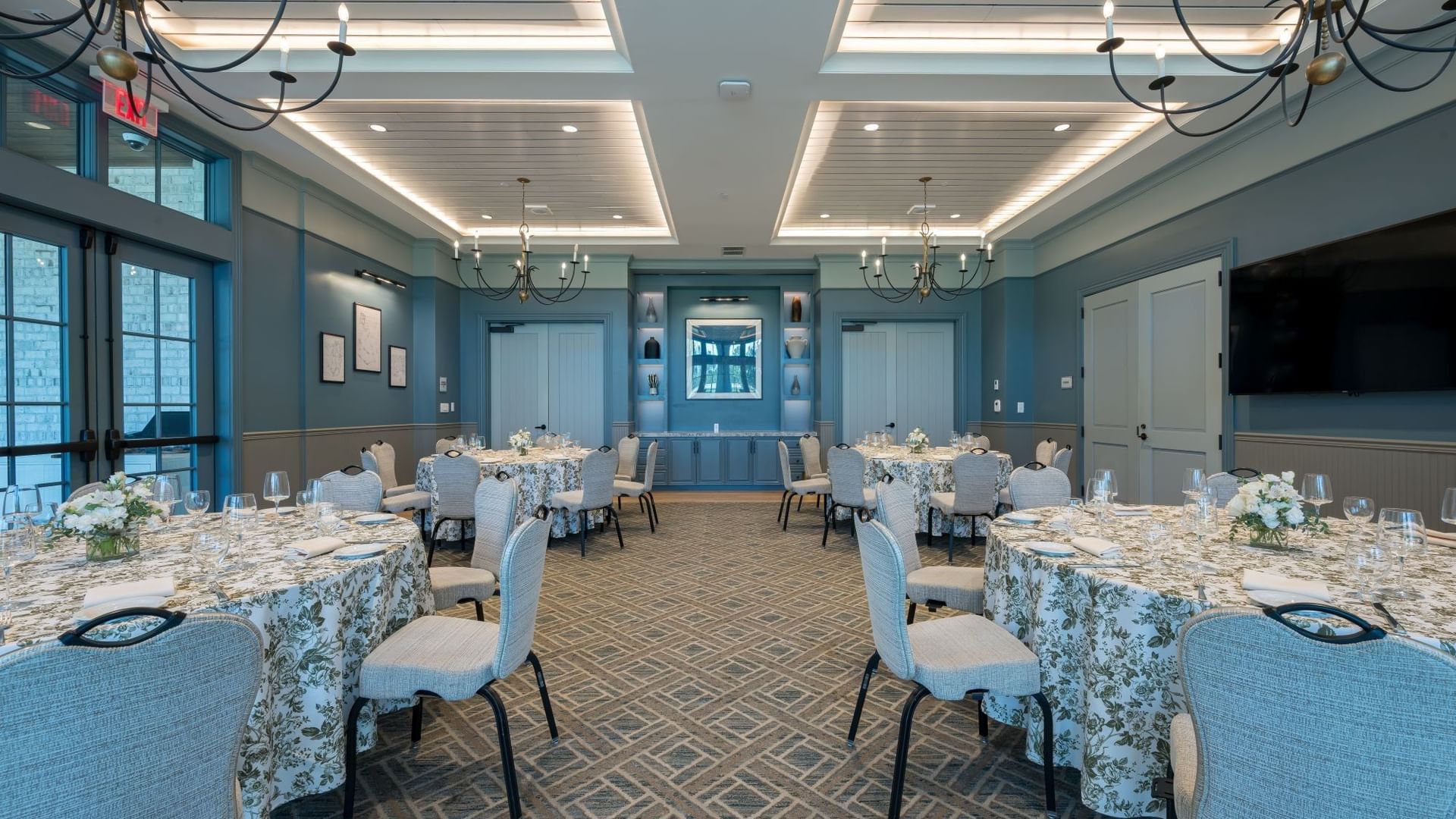 Elegant Club Room with blue walls, chandeliers, and floral-draped tables set for an event at Camp Creek Inn, Inlet Beach.