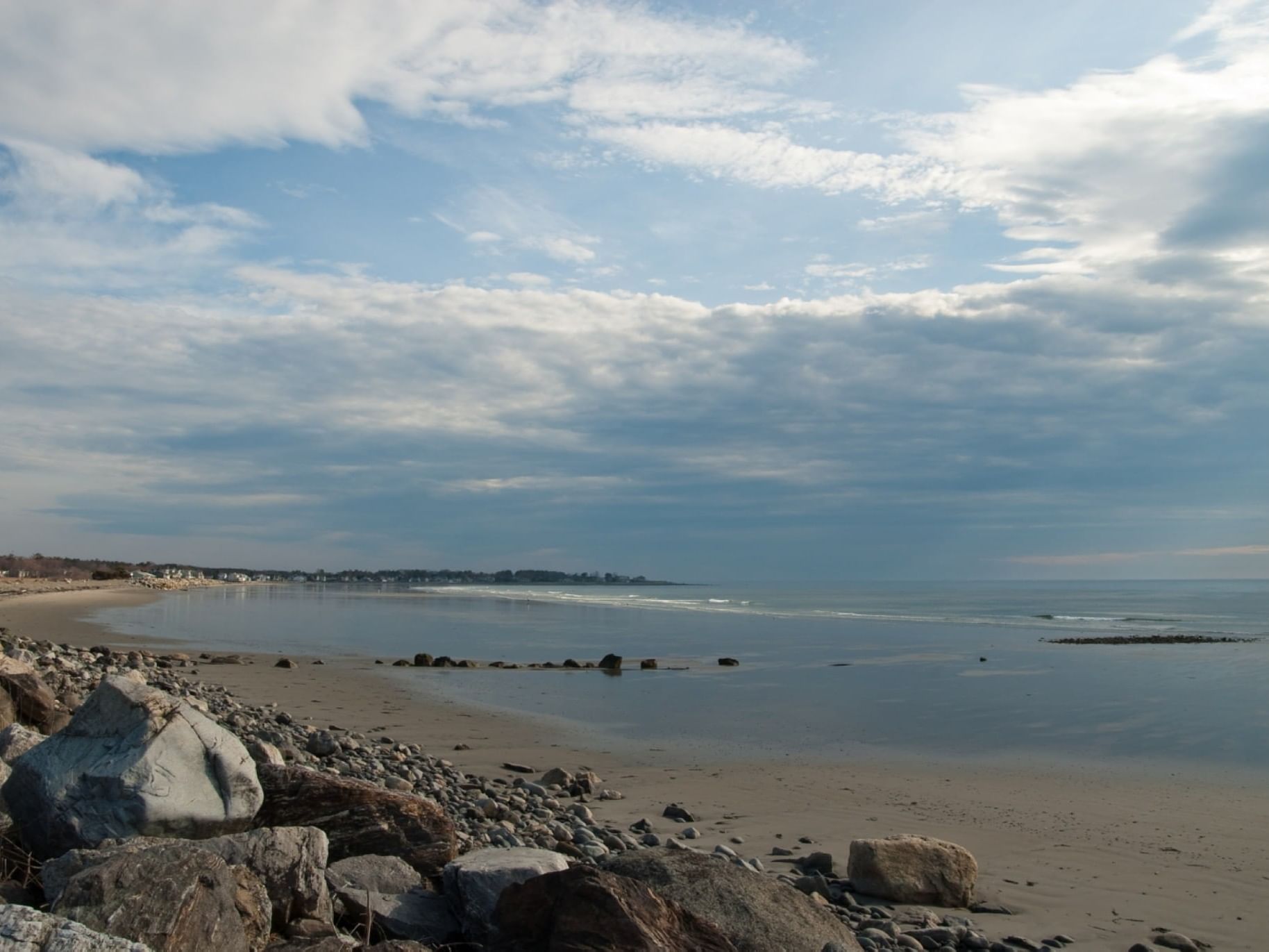 Landscape view of Moody Beach with scattered rocks and cloudy skies near Gorges Grant Hotel