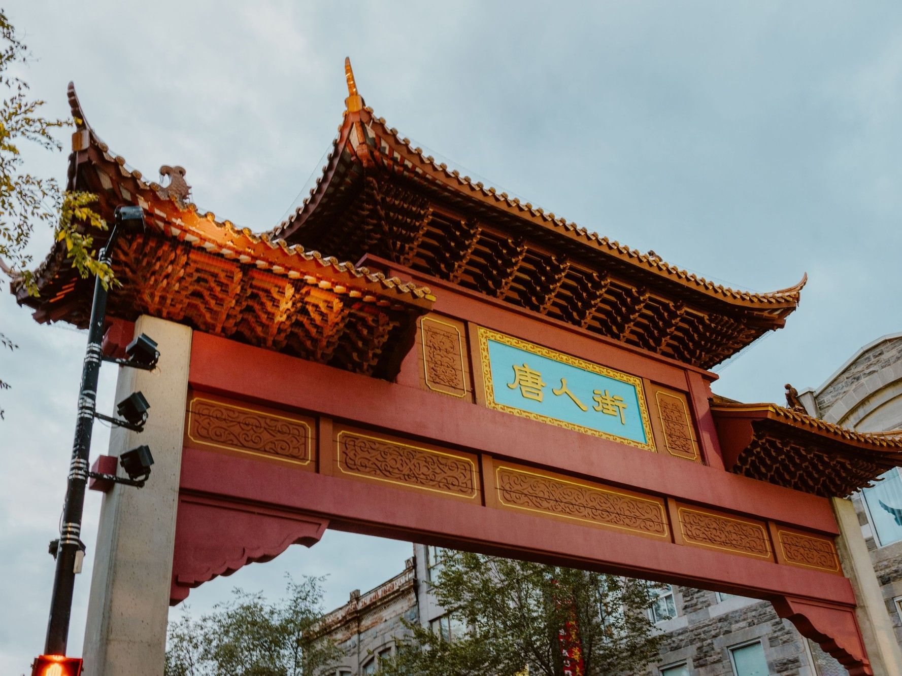 Porte d'entrée ornée de Chinatown avec panneau en chinois et éclairage décoratif.