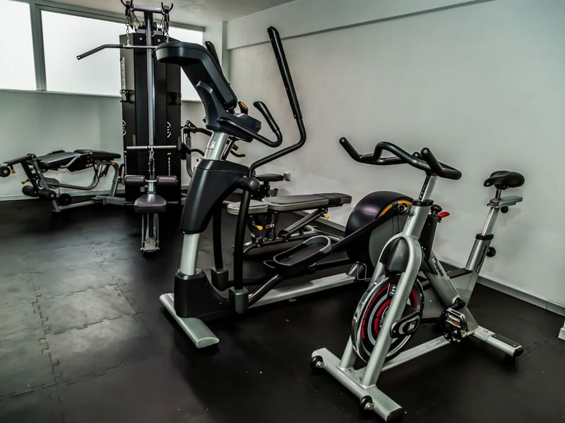 Stationary bikes, fitness training equipment & mirrors in the gym at Gamma Puebla Señorial Centro