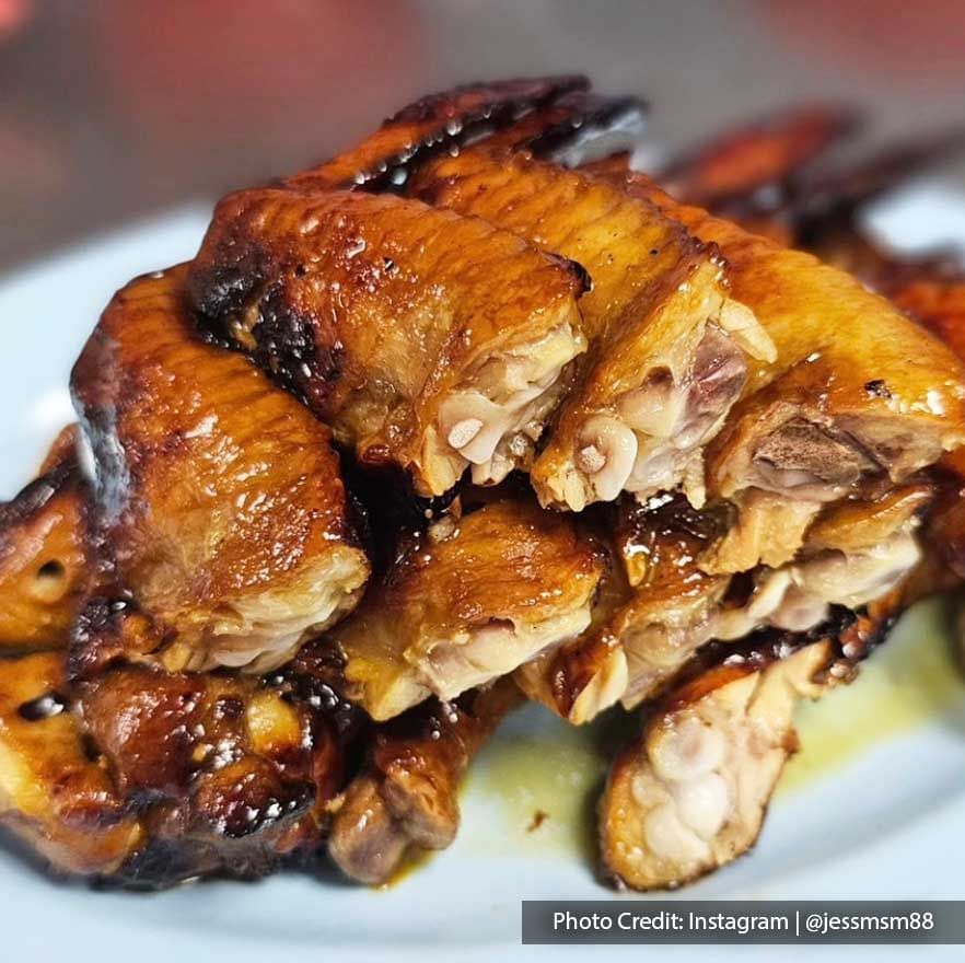 Close-up of a generous plate of grilled chicken wings served in a street food stall near Imperial Lexis Kuala Lumpur