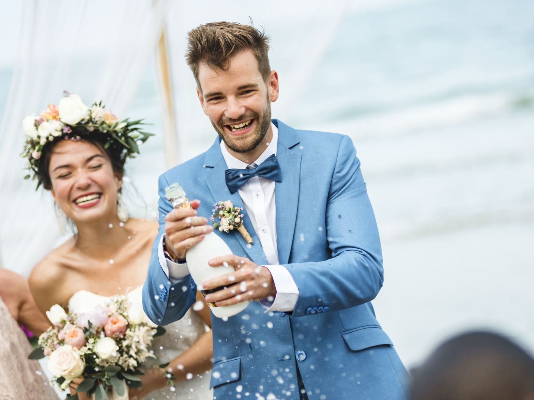 Groom shaking a champagne bottle at Daydream Island Resort