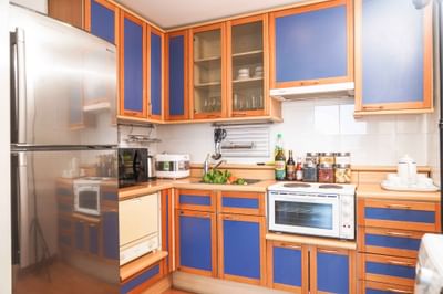 Kitchen with blue cabinets & refrigerator at Hanoi Daewoo Hotel