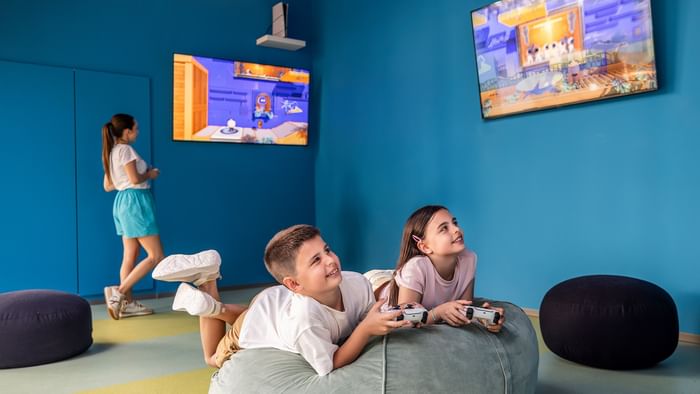Djeca igraju konzolne igre u udobnom igraonicom kod Falkensteiner Group