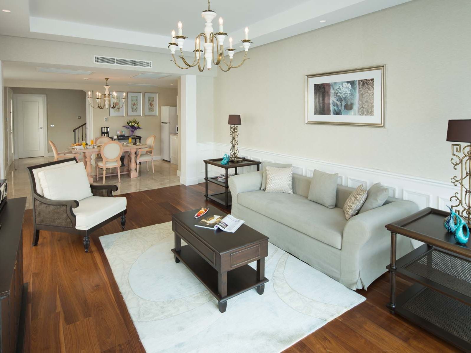 TV lounge area & kitchenette in Design Pool Villa with wooden floors at Titanic Deluxe Golf Belek