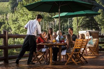 A family dining at an outdoor patio at Stein Eriksen Lodge