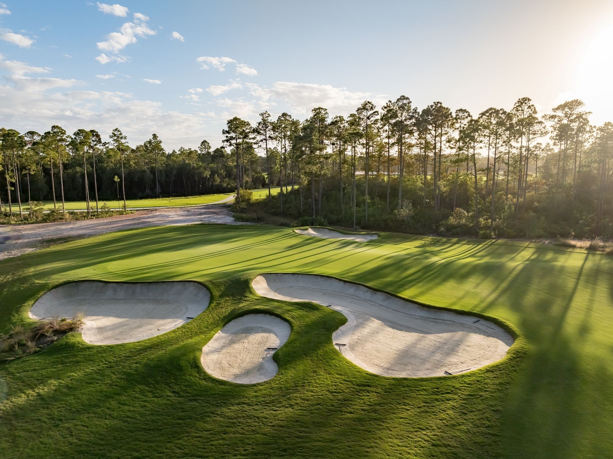 Three sand bunkers on a golf course with trees at Camp Creek Inn's newest golf course, The Third.