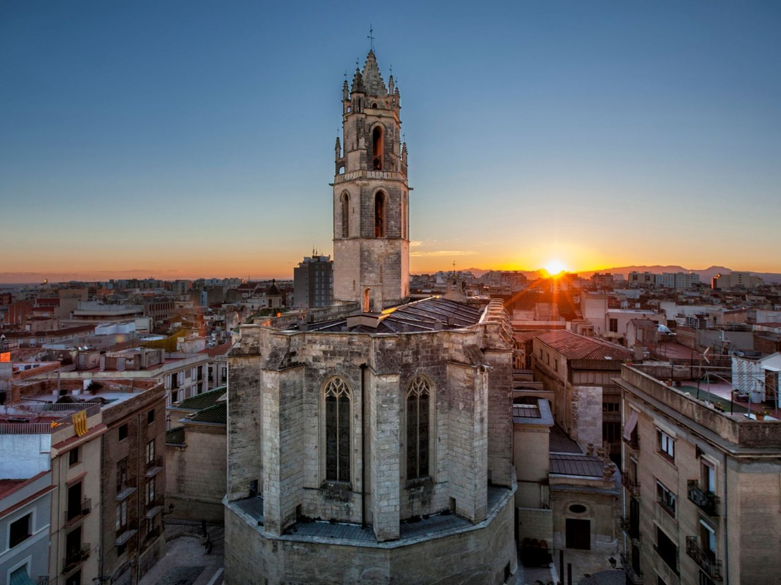 City skyline at sunset with a towering structure near Hotel Piramide Salou