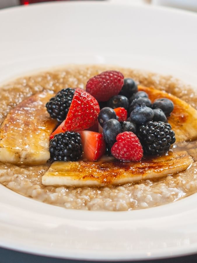 Warm oatmeal with caramelized bananas and fresh berries in The Landmark - Breakfast at Warwick Melrose Dallas