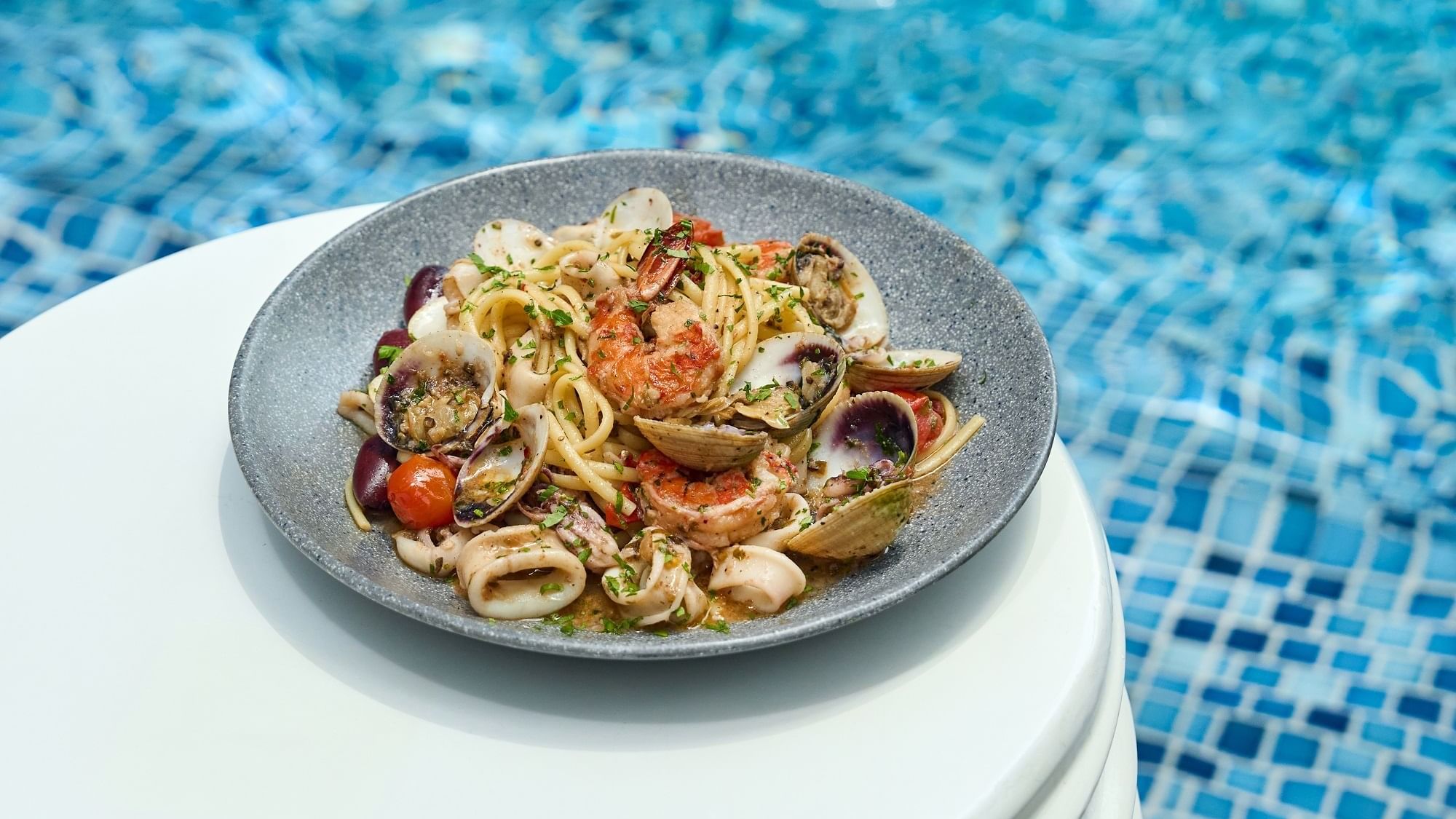 Seafood spaghetti served by the pool edge in Malibu Deck Pool bar at Paramount Hotel Dubai