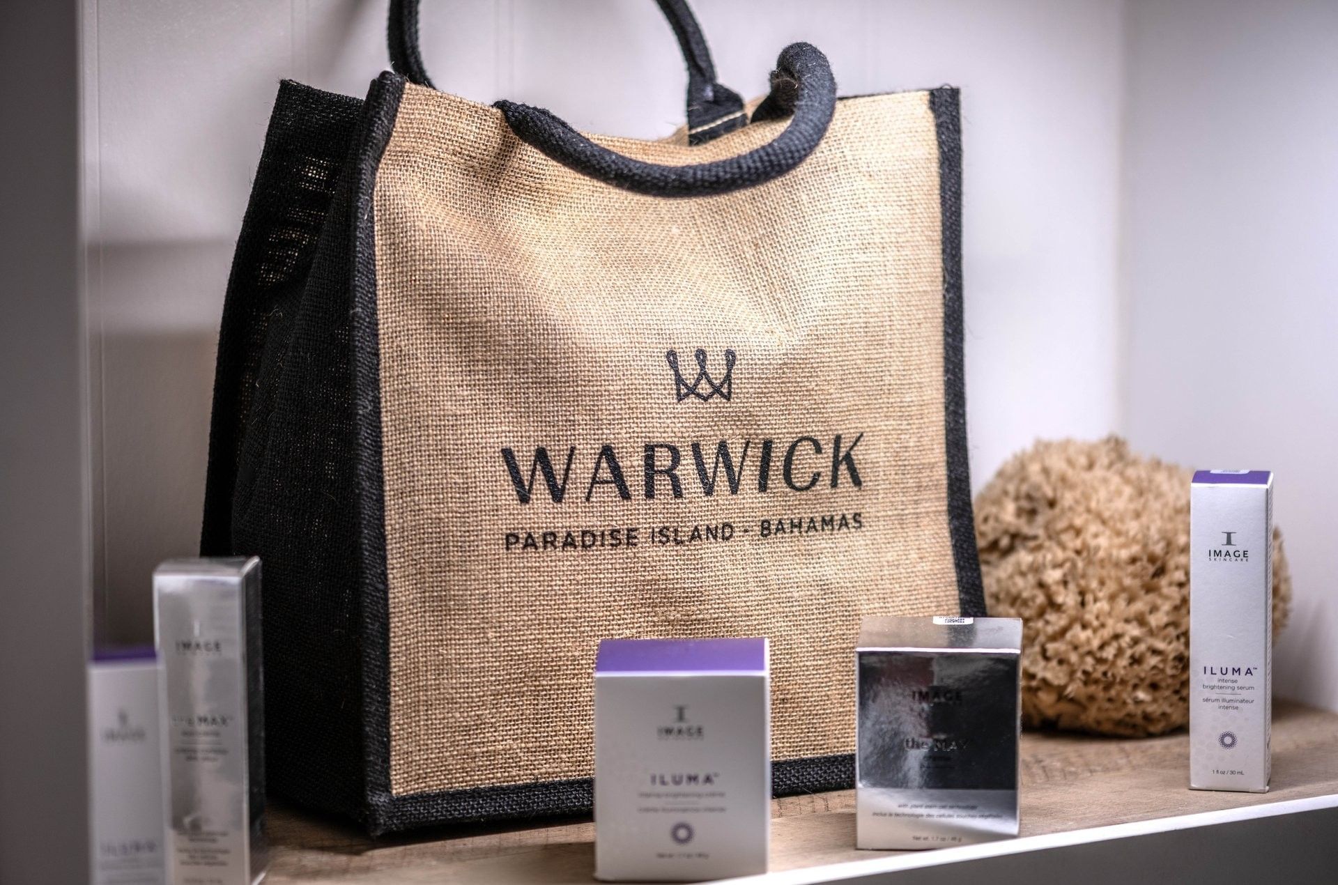 Burlap tote bag by luxury skincare boxes under bright shelf lighting in Spa at Warwick Paradise Island Bahamas