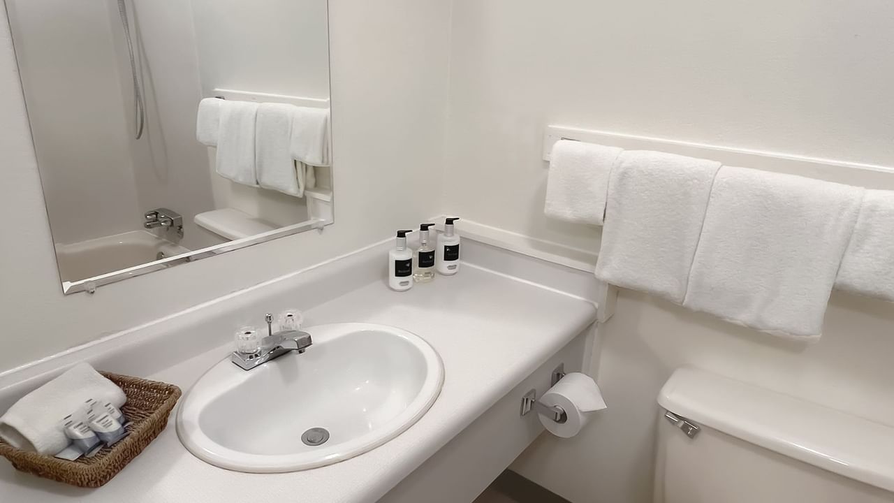 Bathroom with towels, toilet, mirror, sink