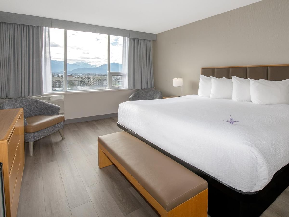 King bed, TV, and view from a large window at Coast Chilliwack Hotel by APA.