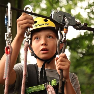 Kid with cables in high-wire course near Falkensteiner Hotels