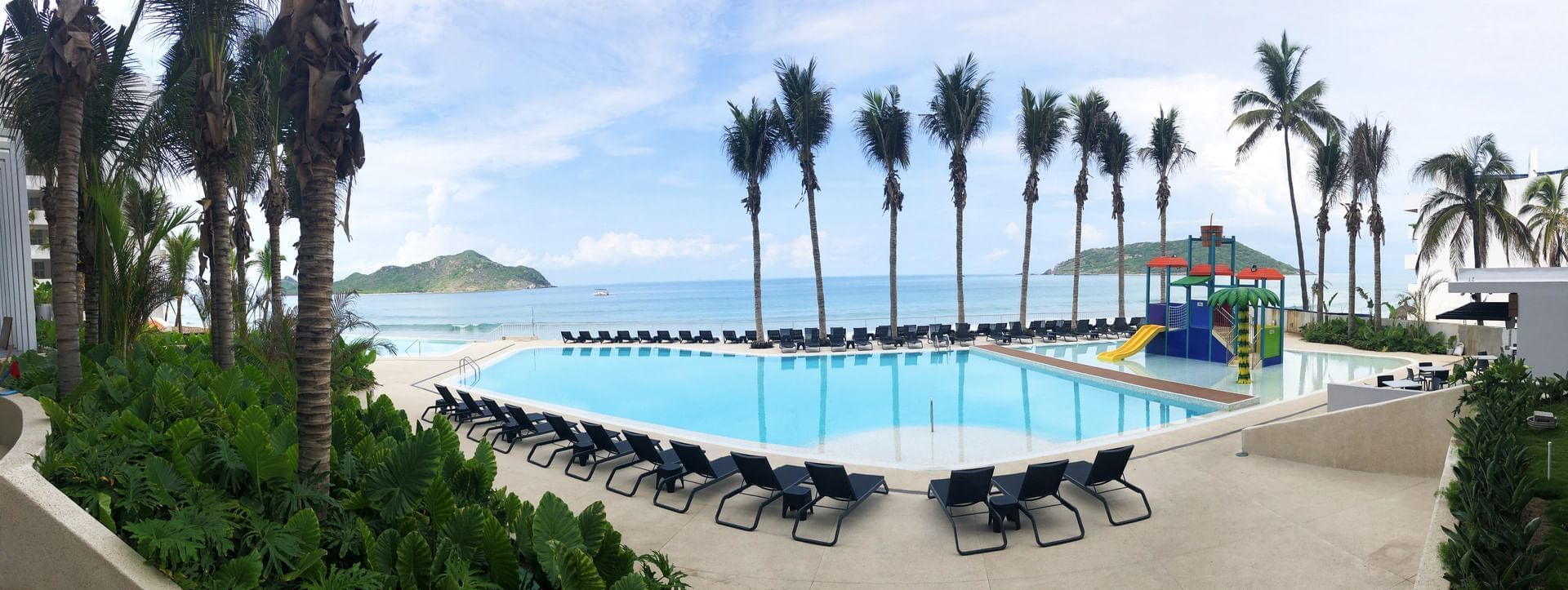 Sun lounges and slide near the pool at Viaggio Resort Mazatlan