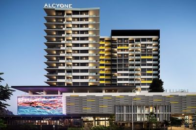 Distant view of the illuminated exterior of Alcyone Hotel Residences