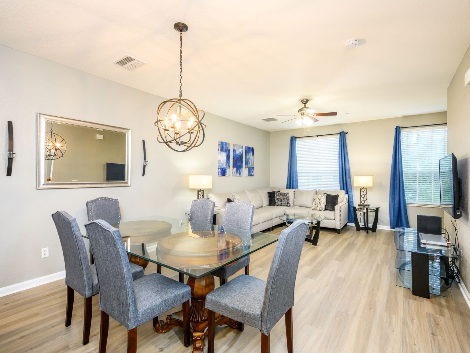 Open-concept living and dining area with modern furnishings and blue accents at Vista Cay Resort By Millenium, Orlando