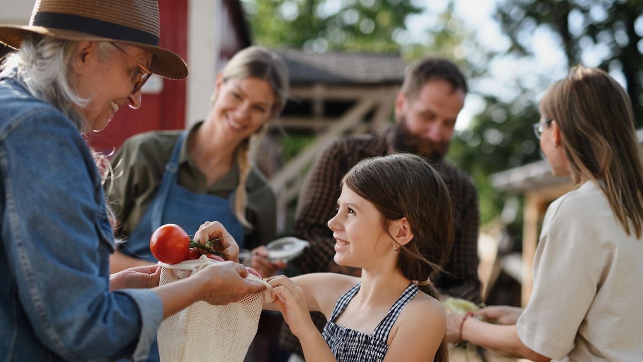 little girl and her family buying vegetables at a local food festival