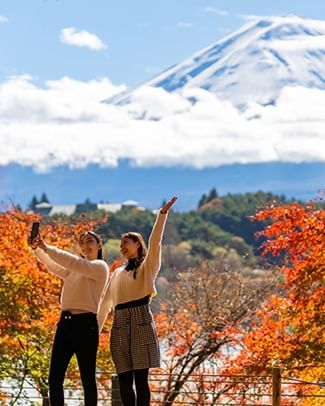 two girls taking a selfie with mt fuji in the background
