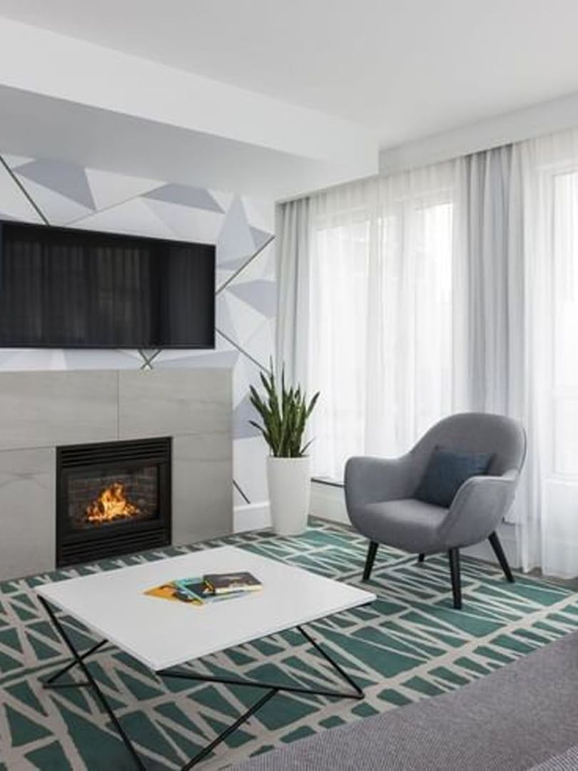 TV lounge with fireplace and sofa near window in Penthouse René-Lévesque at Warwick Le Crystal Montreal
