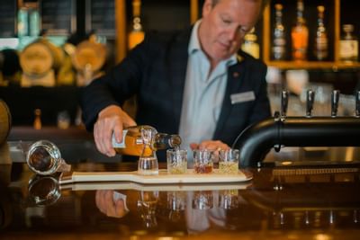 Gentleman pouring flight of cocktails.