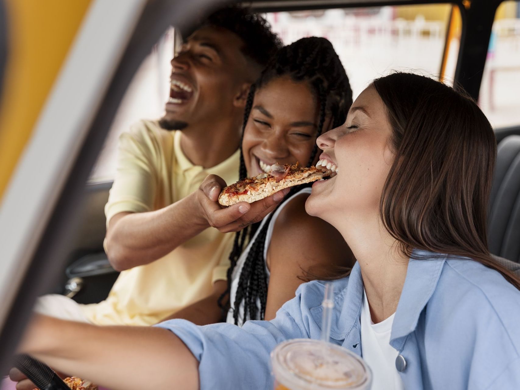 Friends enjoying pizza in the car near Hotel Factory Green