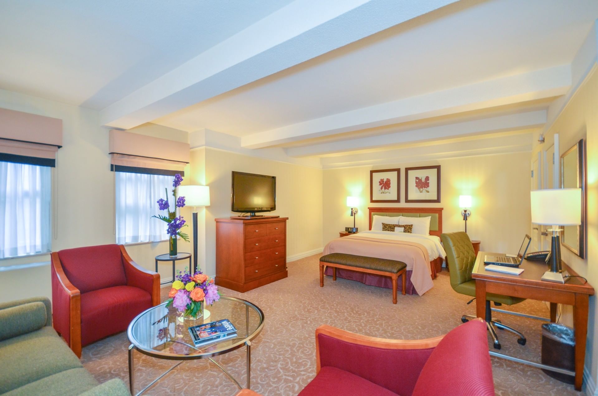 A wide view of a hotel suite with a sitting area and a bedroom.