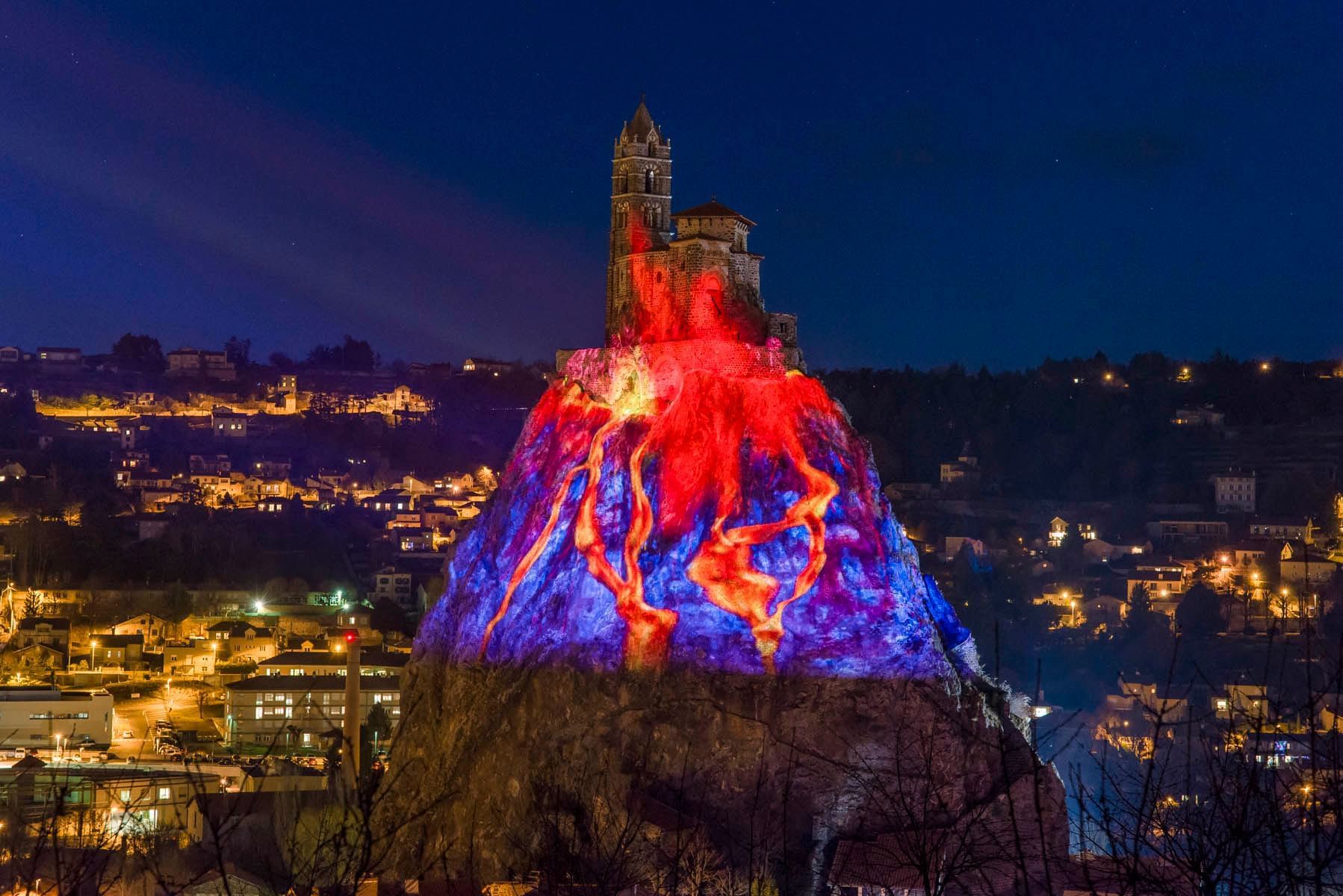 A building on top a mountain decroated with colorful lights