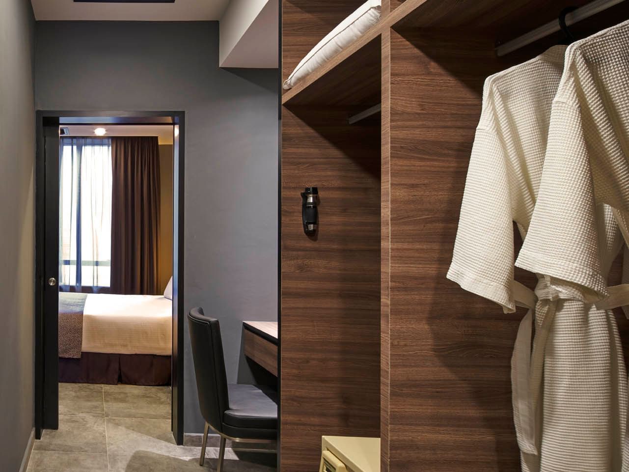 Image 78: Two Bedroom entrance with walk-in wardrobe, bathrobes, desk, and a view into the bedroom at Orchard Grand Court