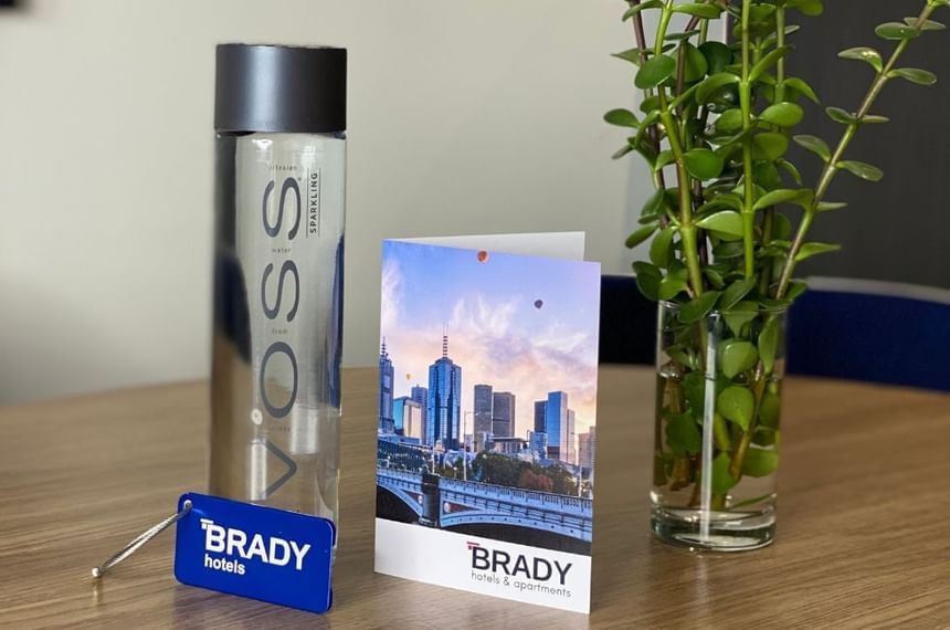 Hotel card & plant by a bottle of Voss at Brady Apartment Hotel Flinders Street