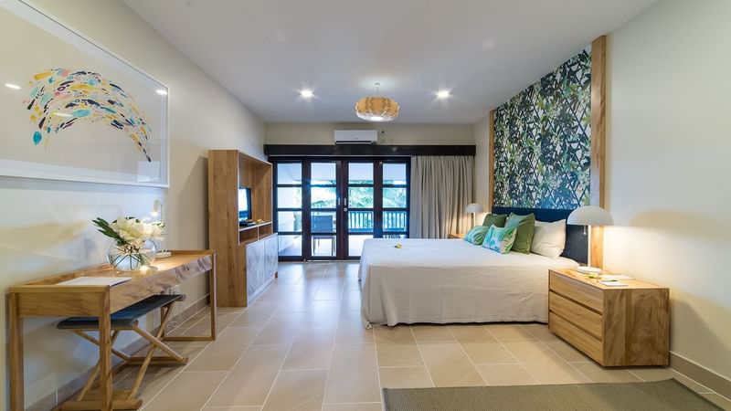 TV, bed & work desk in a guest room at Warwick Le Lagon