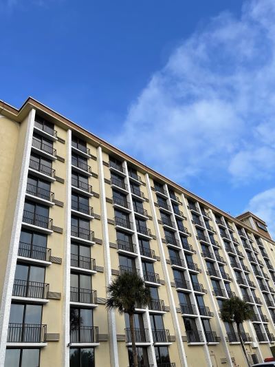 A close up photo of one side of Rosen Inn Closest to Universal showing rows and columns of hotel windows and balconies on a light yellow wall. Take advantage of a free shuttle to the Universal Orlando theme parks while staying at Rosen Inn Closest to Universal.  