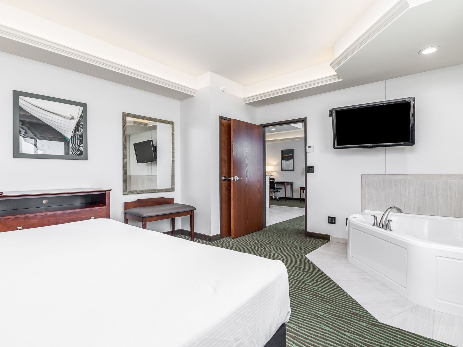 TV and inviting corner bathtub by the cozy bed in King Executive Suite River View at Off Shore Resort
