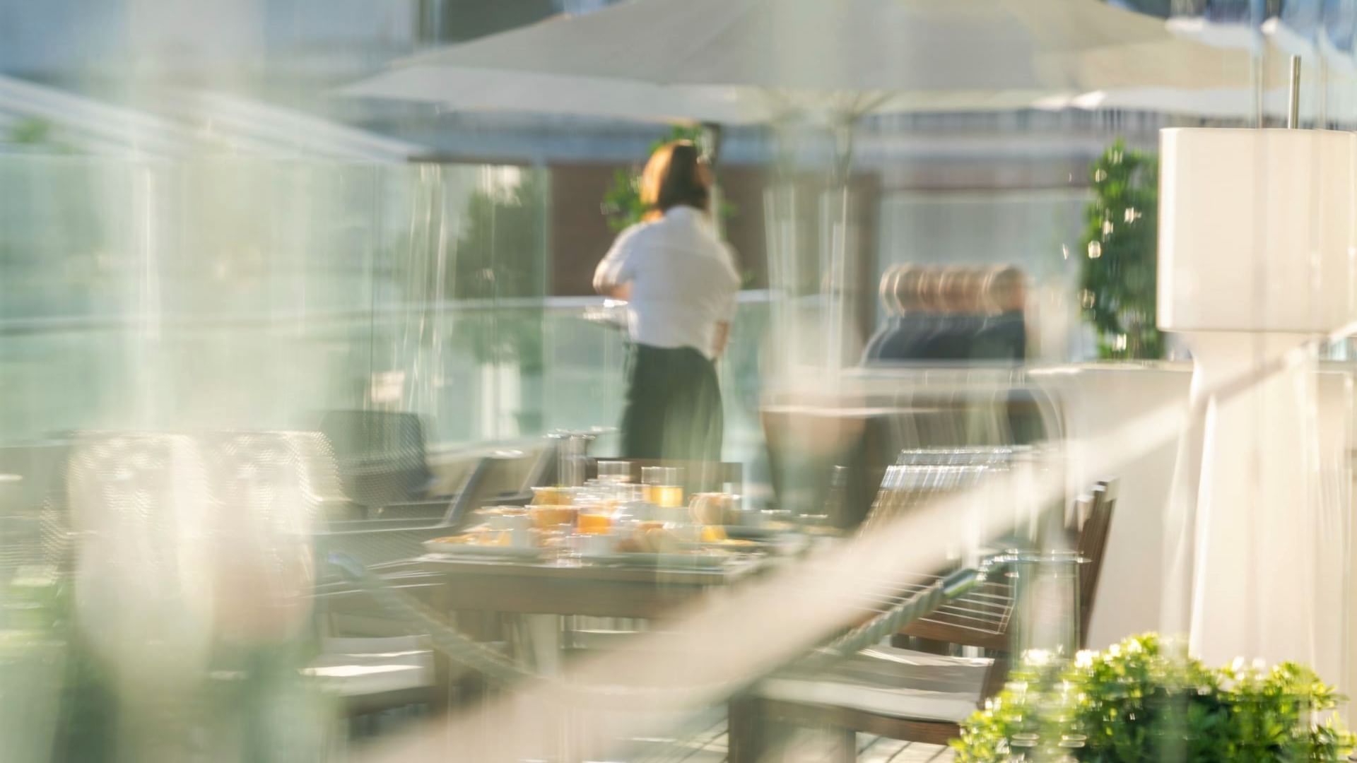 Waitress at an outdoor dine area at Bensaude Hotels Collection