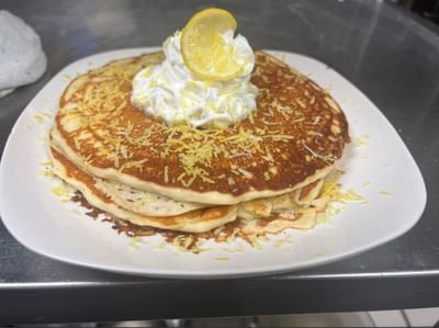 Pancakes topped with whipped cream and lemon in The Boca Beach House near Ocean Lodge Boca Raton