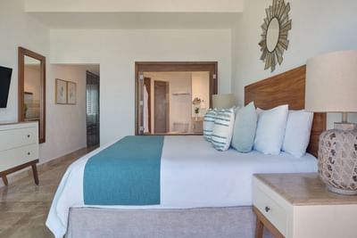 Spacious boutique hotel room showcasing an upscale contemporary design and premium ocean-view bedding.