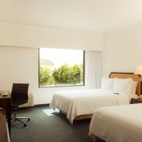 Twin beds with working desk in Superior Room at Fiesta Inn